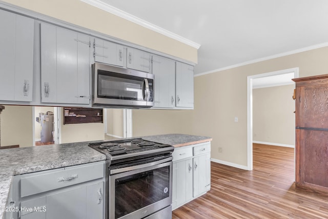 214 Frink Dr, Southport, NC 28461 - kitchen with stainless steel appliances, ornamental molding, light wood-style flooring, baseboards, and light countertops