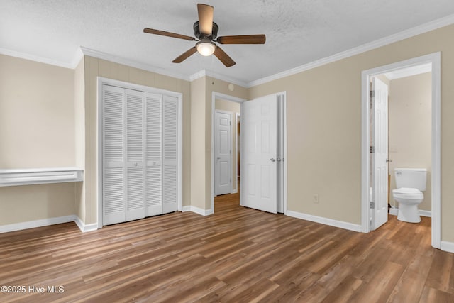 214 Frink Dr, Southport, NC 28461 - unfurnished bedroom with wood finished floors, ornamental molding, baseboards, a closet, and connected bathroom