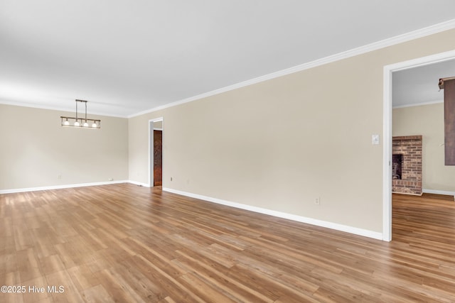 214 Frink Dr, Southport, NC 28461 - unfurnished room featuring a fireplace, light wood-style floors, baseboards, and ornamental molding