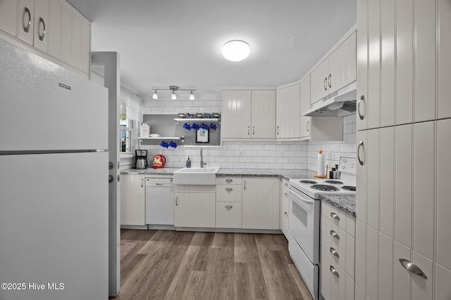 207 Battleground Ave, New Bern, NC 28560 - kitchen with white appliances, under cabinet range hood, wood finished floors, backsplash, and light stone countertops