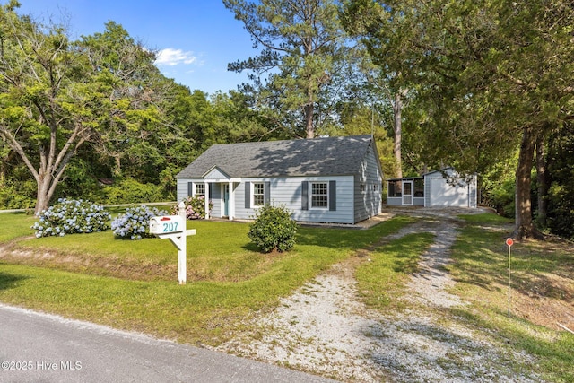 207 Battleground Ave, New Bern, NC 28560 - view of front of house with driveway, an outbuilding, a detached garage, and a front yard