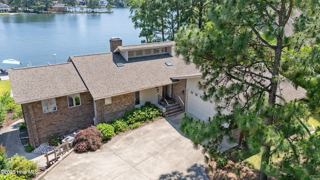 467 Longleaf Dr, West End, NC 27376 - view of front of house with a water view, a chimney, brick siding, an attached garage, and a shingled roof