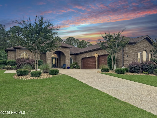 6003 Mount Carmel Parke, Wilmington, NC 28412 - view of front facade with an attached garage, brick siding, concrete driveway, a lawn, and a shingled roof