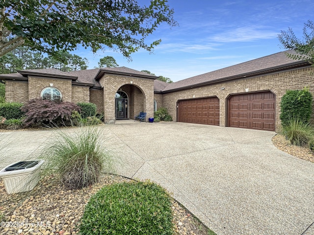 6003 Mount Carmel Parke, Wilmington, NC 28412 - french provincial home with brick siding, a garage, driveway, and roof with shingles