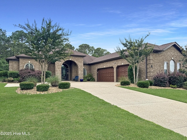 6003 Mount Carmel Parke, Wilmington, NC 28412 - view of front of home with an attached garage, brick siding, concrete driveway, and a front lawn