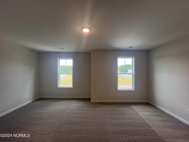 210 Presley St, Raeford, NC 28376 - empty room with healthy amount of natural light, dark colored carpet, and baseboards