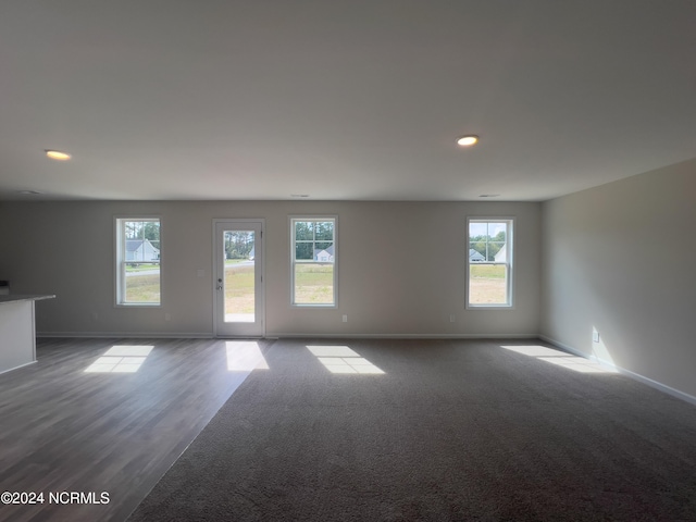 210 Presley St, Raeford, NC 28376 - empty room with healthy amount of natural light, baseboards, recessed lighting, and dark colored carpet