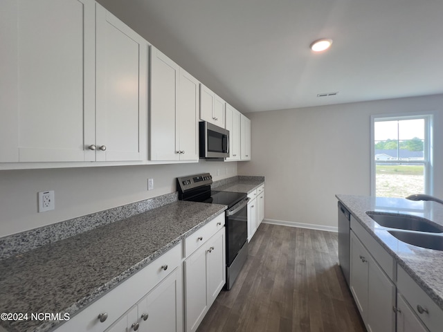 210 Presley St, Raeford, NC 28376 - kitchen featuring stainless steel appliances, a sink, light stone countertops, dark wood-style floors, and baseboards