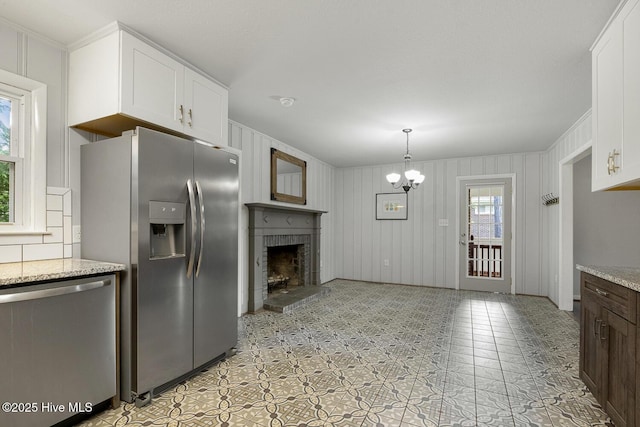 780 Leslie Campbell Ave, Lillington, NC 27546 - kitchen featuring stainless steel appliances, white cabinets, a fireplace, light stone countertops, and crown molding