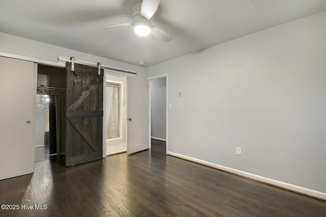 780 Leslie Campbell Ave, Lillington, NC 27546 - unfurnished bedroom featuring a barn door, wood finished floors, baseboards, and ceiling fan