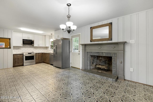 780 Leslie Campbell Ave, Lillington, NC 27546 - kitchen featuring stainless steel appliances, a decorative wall, pendant lighting, tasteful backsplash, and a brick fireplace