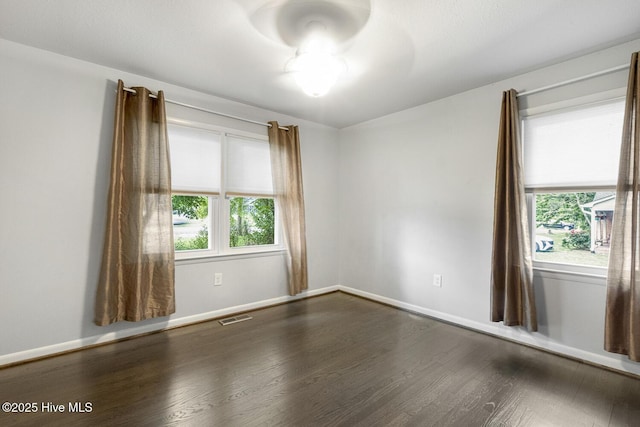 780 Leslie Campbell Ave, Lillington, NC 27546 - unfurnished room featuring healthy amount of natural light, dark wood-style floors, and baseboards