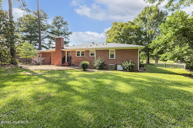 780 Leslie Campbell Ave, Lillington, NC 27546 - rear view of house featuring entry steps, a chimney, brick siding, a patio, and central air condition unit