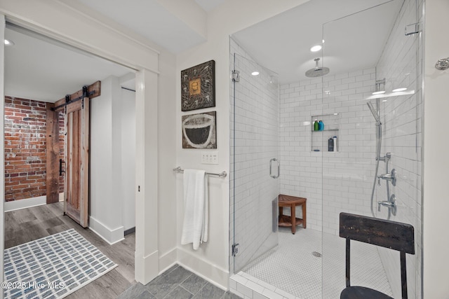 183 W Main St Unit 205, Washington, NC 27889 - full bathroom featuring a stall shower, wood finished floors, and brick wall