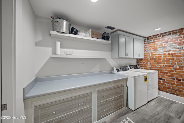 183 W Main St Unit 205, Washington, NC 27889 - washroom featuring brick wall, washing machine and dryer, cabinet space, light wood finished floors, and recessed lighting