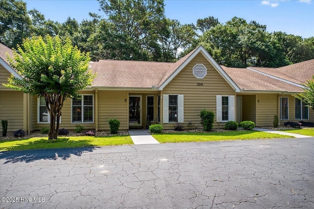 354 Sea Trail Dr E Unit 2, Sunset Beach, NC 28468 - ranch-style house with a shingled roof and a front lawn