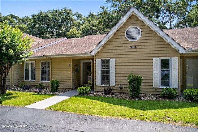 354 Sea Trail Dr E Unit 2, Sunset Beach, NC 28468 - ranch-style house featuring a shingled roof and a front lawn