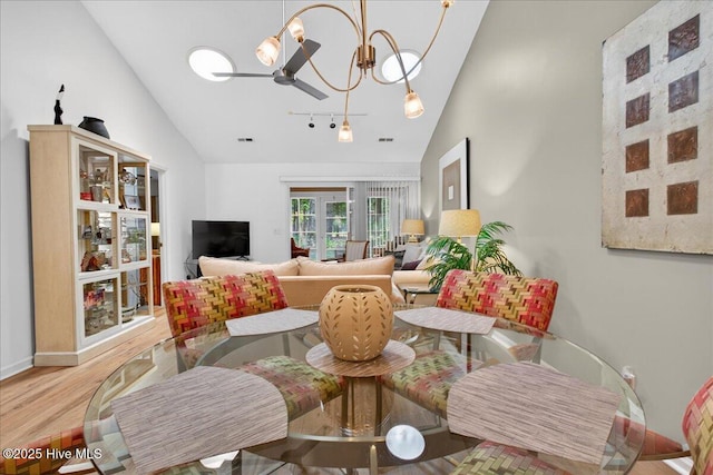 354 Sea Trail Dr E Unit 2, Sunset Beach, NC 28468 - living area with wood finished floors, rail lighting, high vaulted ceiling, a chandelier, and baseboards