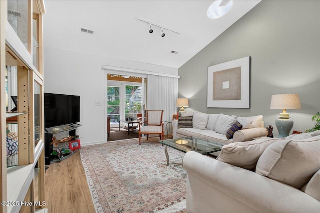 354 Sea Trail Dr E Unit 2, Sunset Beach, NC 28468 - living room with rail lighting, wood finished floors, high vaulted ceiling, and baseboards
