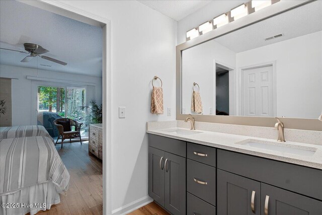 354 Sea Trail Dr E Unit 2, Sunset Beach, NC 28468 - bathroom featuring ensuite bathroom, double vanity, a ceiling fan, wood finished floors, and baseboards