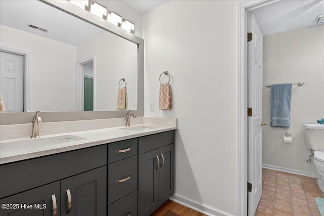 354 Sea Trail Dr E Unit 2, Sunset Beach, NC 28468 - full bath with toilet, double vanity, baseboards, and a textured ceiling