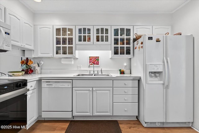 354 Sea Trail Dr E Unit 2, Sunset Beach, NC 28468 - kitchen with white appliances, a sink, white cabinets, crown molding, and light wood-style flooring
