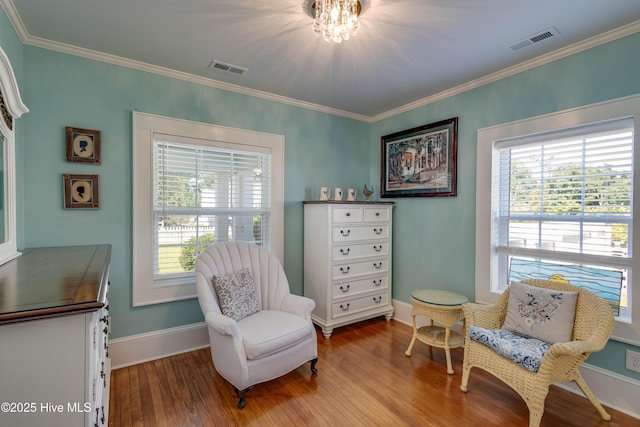 528 E 6th St, Washington, NC 27889 - sitting room featuring wood finished floors, healthy amount of natural light, ornamental molding, and a chandelier