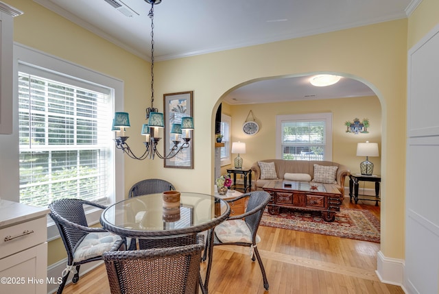 528 E 6th St, Washington, NC 27889 - dining room featuring arched walkways, light wood-type flooring, ornamental molding, and a chandelier