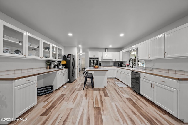 4967 E NC-24 Hwy, Beulaville, NC 28518 - kitchen featuring black appliances, a breakfast bar, a sink, white cabinets, and glass insert cabinets