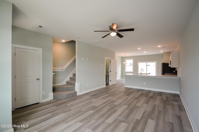 332 Starfish Ln, Sneads Ferry, NC 28460 - unfurnished living room with wood finished floors, ceiling fan, stairway, and recessed lighting