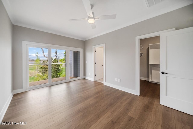 2593 Alvernia Dr, Castle Hayne, NC 28429 - unfurnished bedroom featuring baseboards, dark wood finished floors, a walk in closet, access to exterior, and a ceiling fan
