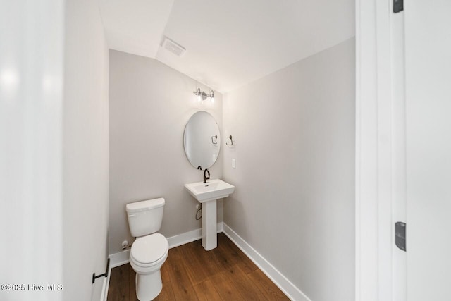 2593 Alvernia Dr, Castle Hayne, NC 28429 - half bathroom featuring baseboards, wood finished floors, toilet, a sink, and vaulted ceiling