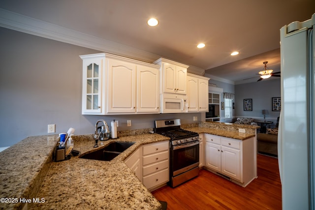 3804 Wyattwood Dr N, Wilson, NC 27896 - kitchen featuring stainless steel range with gas cooktop, a sink, white microwave, crown molding, and a peninsula