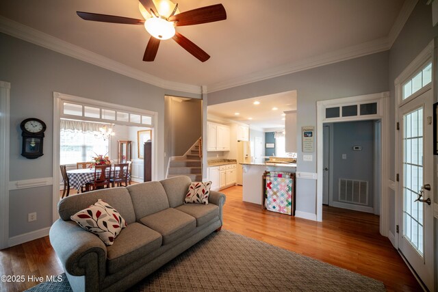 3804 Wyattwood Dr N, Wilson, NC 27896 - living room featuring stairway, ornamental molding, light wood-style flooring, ceiling fan, and baseboards