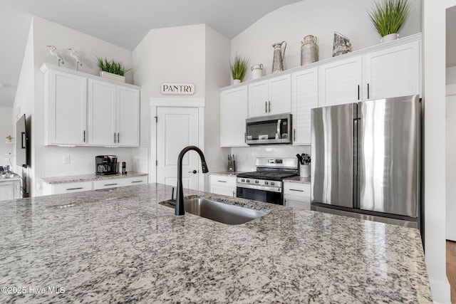2968 Hatchers Run, Leland, NC 28451 - kitchen with stainless steel appliances, a sink, white cabinets, backsplash, and lofted ceiling