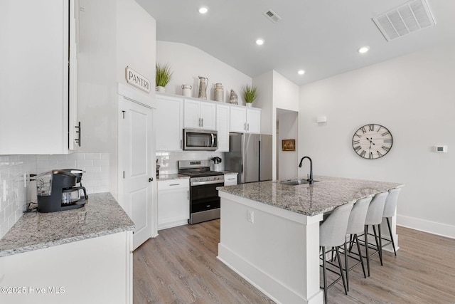 2968 Hatchers Run, Leland, NC 28451 - kitchen featuring stainless steel appliances, a sink, an island with sink, vaulted ceiling, and white cabinets