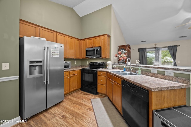 3106 John Willis Rd, New Bern, NC 28562 - kitchen featuring black appliances, a sink, a peninsula, light wood-style floors, and high vaulted ceiling