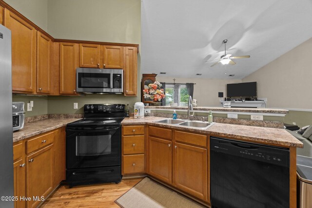 3106 John Willis Rd, New Bern, NC 28562 - kitchen featuring black appliances, a sink, a peninsula, light wood-style floors, and lofted ceiling