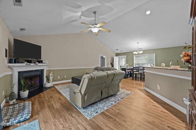 3106 John Willis Rd, New Bern, NC 28562 - living area featuring a fireplace with flush hearth, vaulted ceiling, baseboards, light wood-style flooring, and ceiling fan