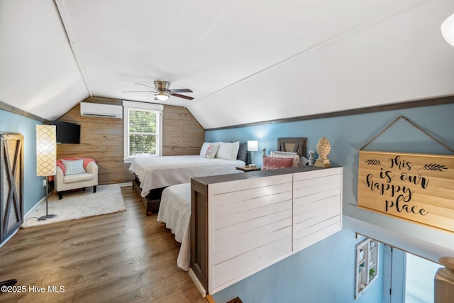 135 NE 34th St, Oak Island, NC 28465 - bedroom with a wall unit AC, wood finished floors, vaulted ceiling, wooden walls, and a ceiling fan