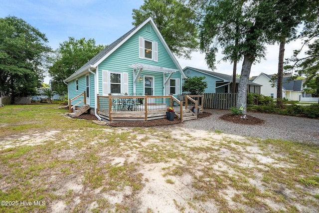 135 NE 34th St, Oak Island, NC 28465 - view of front of house with a wooden deck