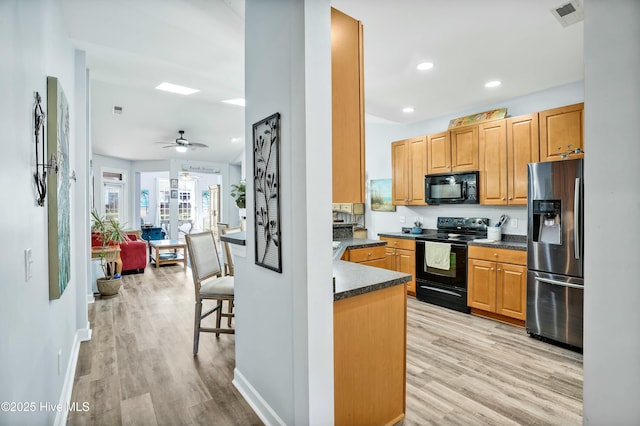 1335 Arbor Ridge Way, Leland, NC 28451 - kitchen featuring black appliances, dark countertops, light wood finished floors, ceiling fan, and recessed lighting