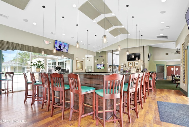 1335 Arbor Ridge Way, Leland, NC 28451 - community bar area featuring wood finished floors, hanging light fixtures, and high vaulted ceiling