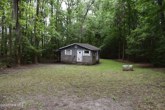 417 River Rd, Blounts Creek, NC 27814 - view of grassy yard featuring an outbuilding and a forest view
