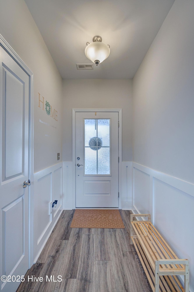 2161 Blue Bonnet Cir, Castle Hayne, NC 28429 - doorway featuring wainscoting, dark wood-type flooring, and a decorative wall