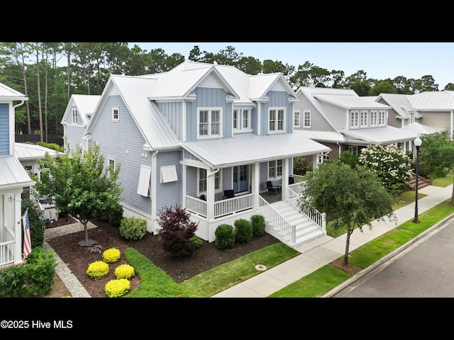 1012 Midnight Channel Rd, Wilmington, NC 28403 - view of front facade with a porch, board and batten siding, and metal roof