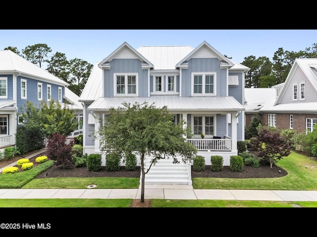 1012 Midnight Channel Rd, Wilmington, NC 28403 - view of front of property with a porch, a front yard, board and batten siding, and metal roof