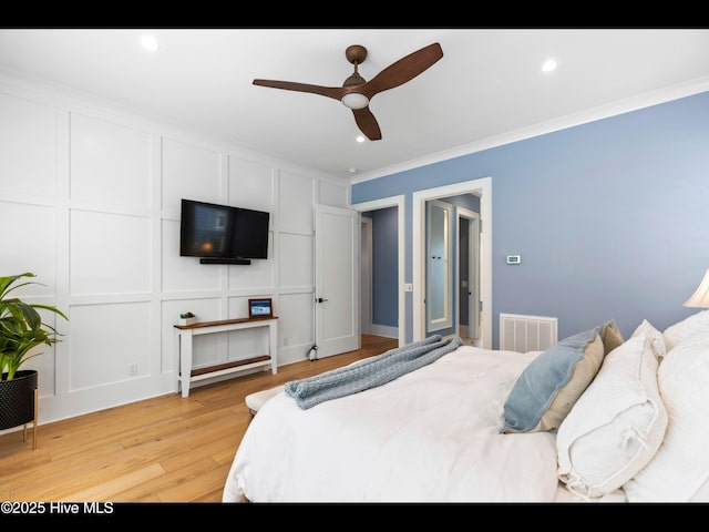 1012 Midnight Channel Rd, Wilmington, NC 28403 - bedroom featuring a decorative wall, light wood-style floors, crown molding, recessed lighting, and a ceiling fan