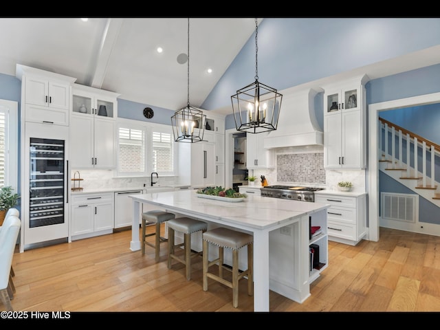 1012 Midnight Channel Rd, Wilmington, NC 28403 - kitchen with open shelves, a sink, custom range hood, a center island, and decorative backsplash