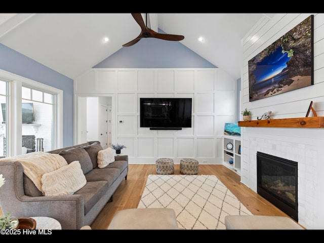 1012 Midnight Channel Rd, Wilmington, NC 28403 - living room featuring a glass covered fireplace, a ceiling fan, light wood-type flooring, and a decorative wall